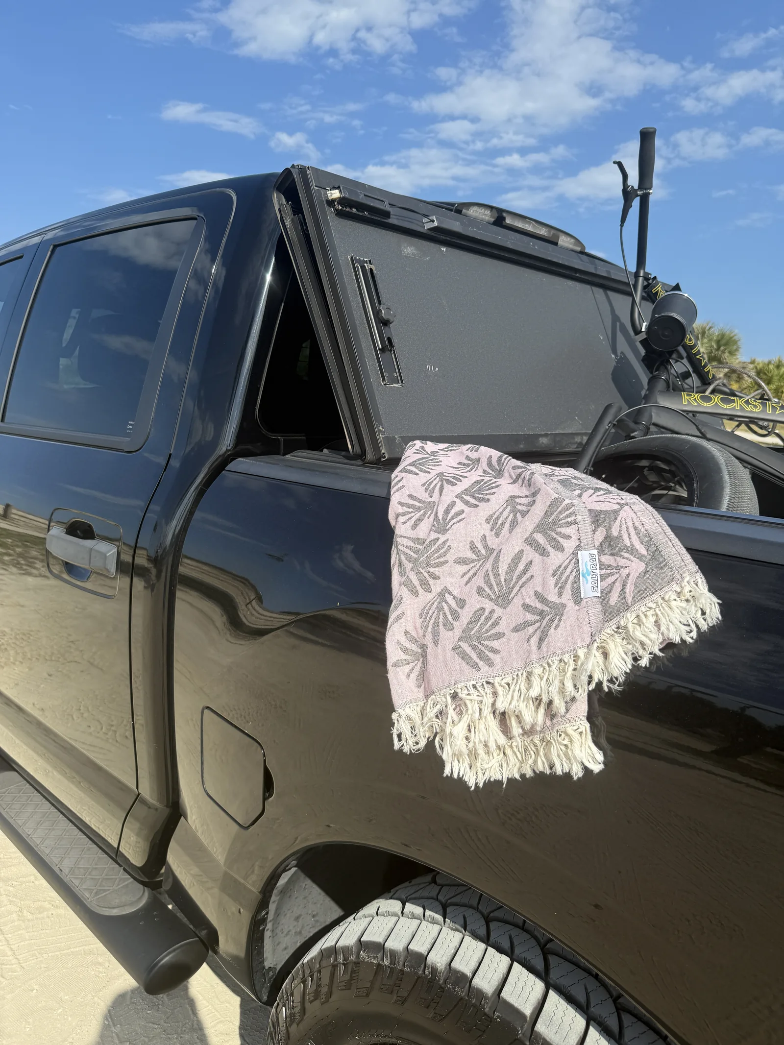 Leaf-patterned Salt Rag draped over the side of a black truck below an open canopy window.