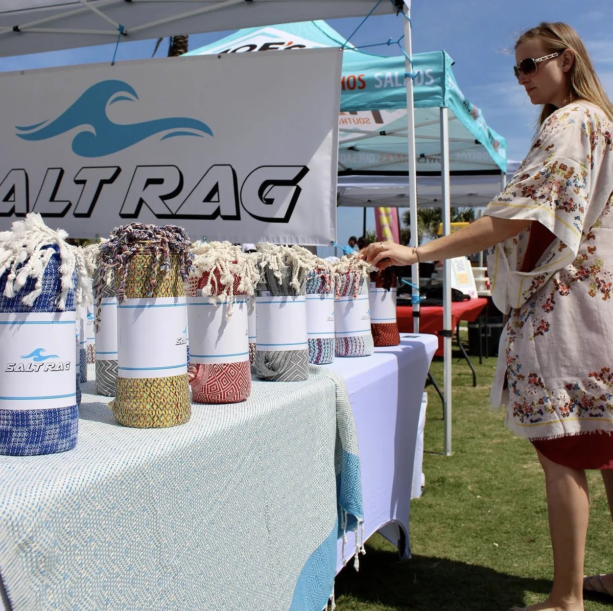 A shopper browsing rolled Rags at the Salt Rag market table.