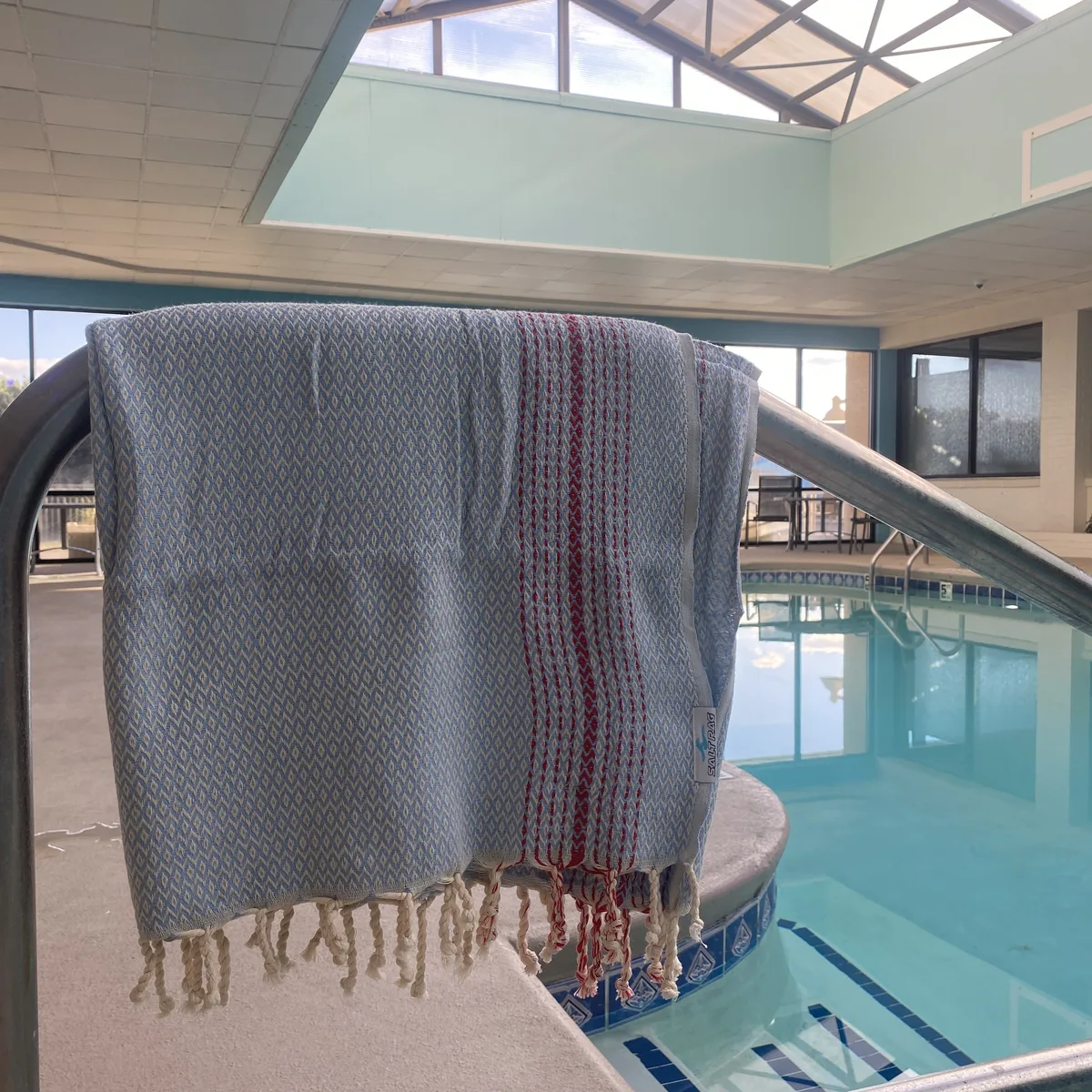 Striped Salt Rag draped over a railing beside an indoor swimming pool.