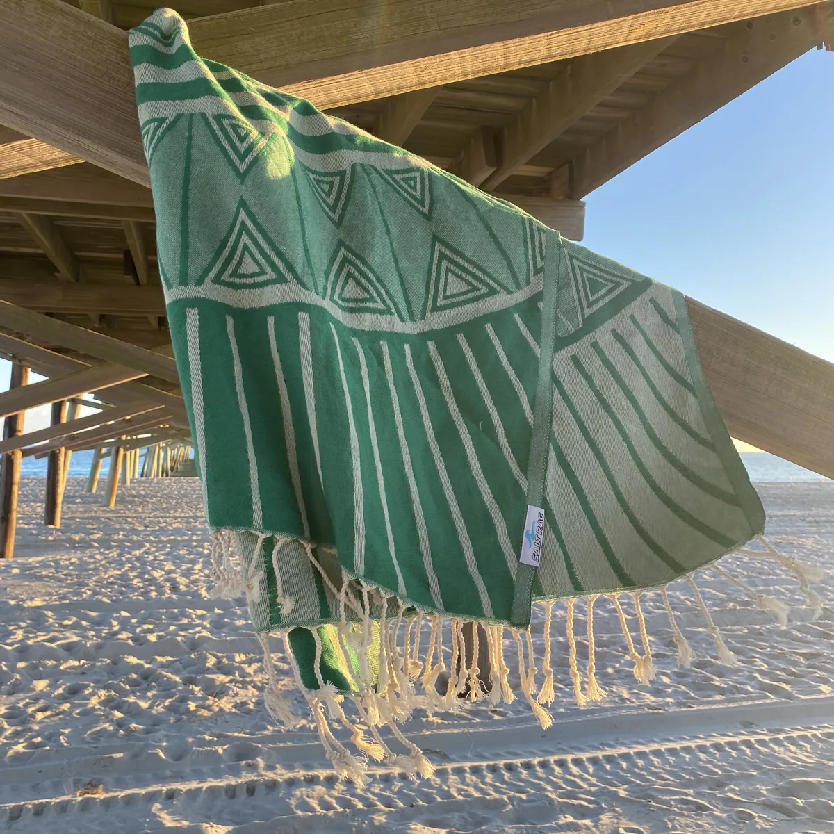 Green patterned Salt Rag displayed open beneath a wooden waterfront shelter.