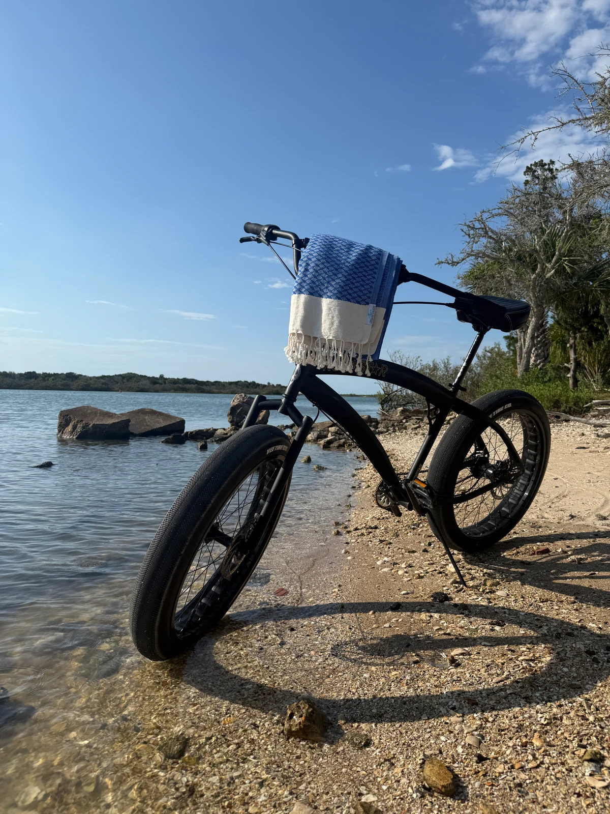 Blue striped Salt Rag rolled on a bicycle beside the water.