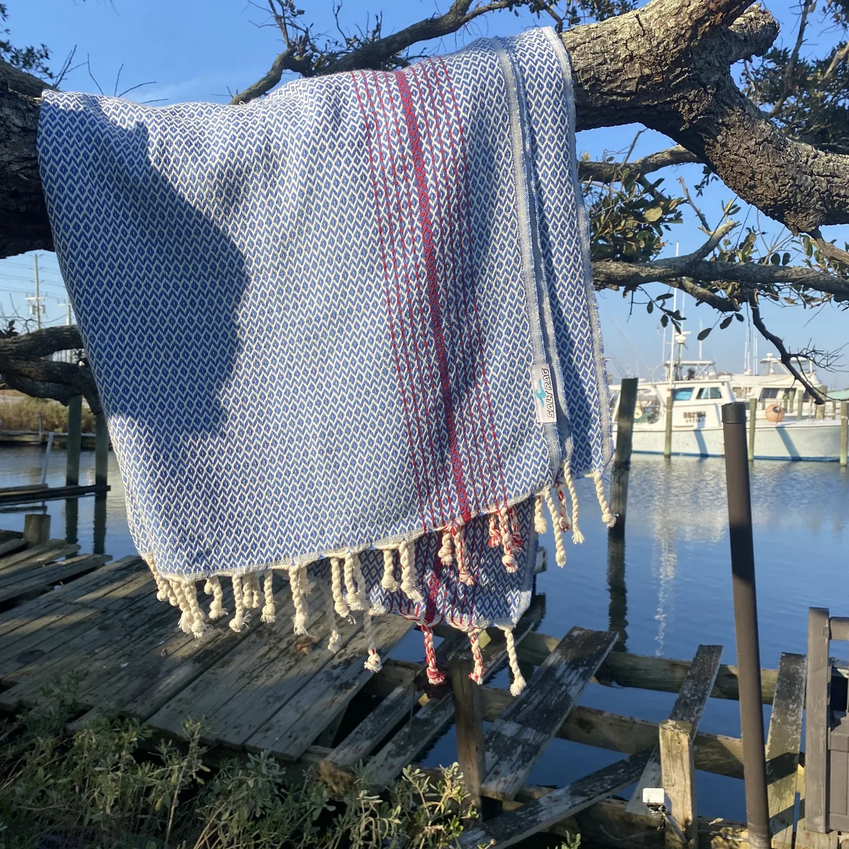 Blue and pink striped Salt Rag hanging from a waterfront tree.